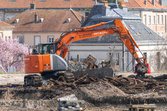 Mirecourt, France - March 21st 2026 : View on an orange crawler excavator Hitachi ZX135US for the demolition of a building on a construction site.