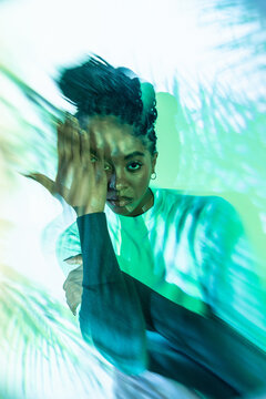Afro woman dancer portrait with motion blur and teal light