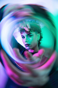 Cyberpunk young woman in neon light with lens swirl effect