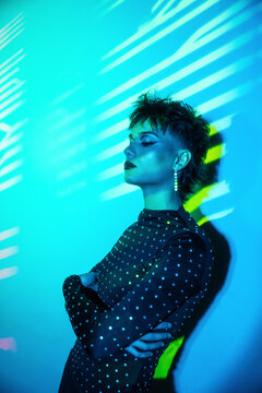 Cyberpunk young woman in neon light with shadow stripes