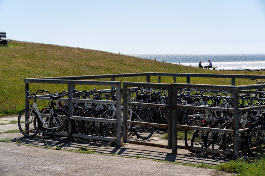 Bicycles in a wooden rack by a grassy dike on Langene&szlig; island