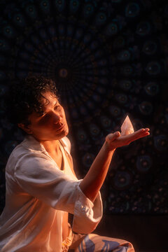 Spiritual Latin woman holding crystal in warm mystic light