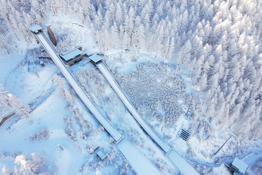 Aerial view of Stadio Olimpico del Salto surrounded by snow-covered pine forests in the winter in Pragelato, Piedmont, Italy.