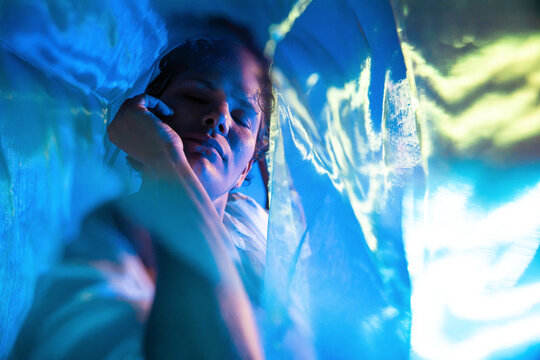 Spiritual Latin woman in blue light veil meditative dream