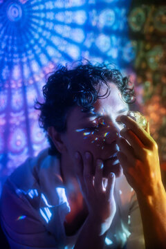 Spiritual Latin woman holding crystal in rainbow light glow