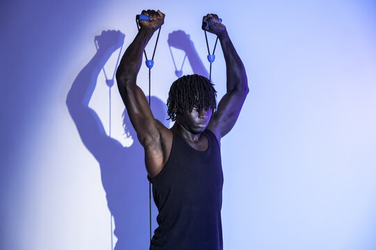 Black athlete stretching with resistance band in studio