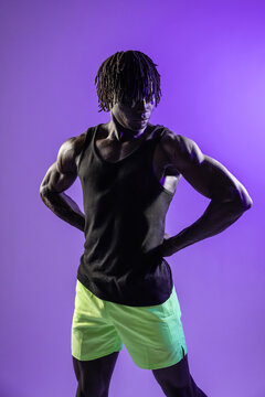 Black athlete posing in studio with purple background