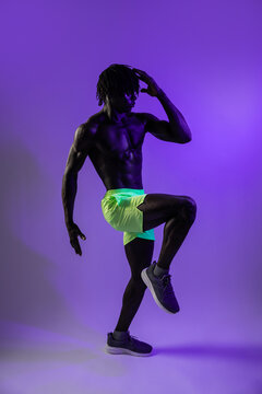 Studio portrait of athlete doing high knee stretch