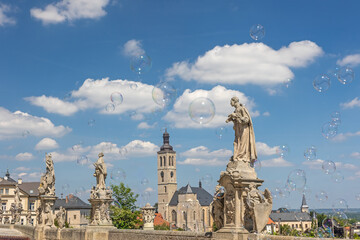 Obraz premium Famous historical town of Kutna Hora. Soap bubbles are flying in the foreground. Czech Republic.