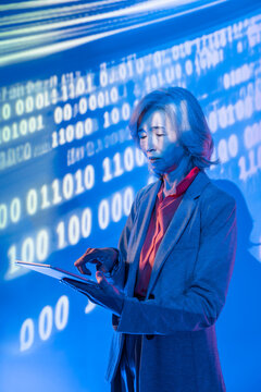 Futuristic senior Asian woman using tablet with data