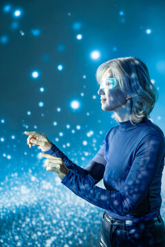 Futuristic senior Asian woman using holographic interface