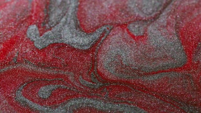 Paint spatter. Spill texture. Defocused red silver colorful blend particles acrylic liquid floating on abstract creative background.