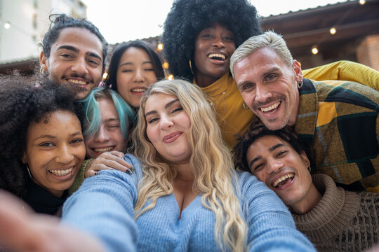 Cheerful group of diverse friends posing together for a group selfie