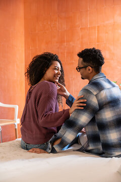 Latin couple sharing a tender moment on bed at home