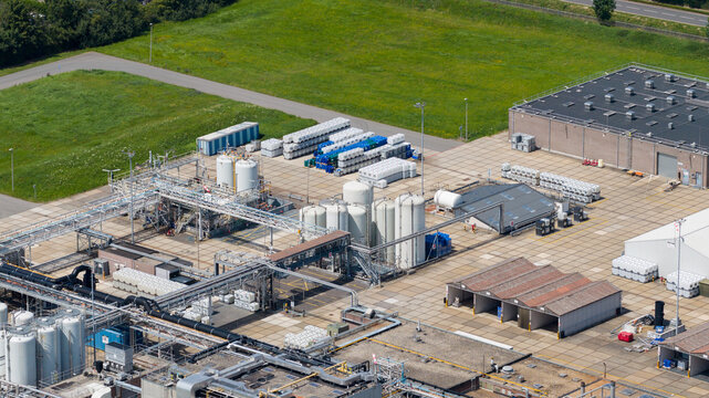 Aerial view of the Seqora B.V. industrial facility featuring storage tanks, complex piping systems, and warehouse buildings in a paved logistics yard in Zaltbommel, Gelderland, Netherlands.
