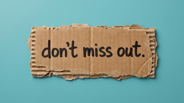 Textured cardboard sign featuring handwritten message don t miss out isolated on soft blue studio background representing urgent call to action or promotional marketing announcement.