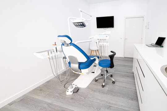 Modern dental clinic room with chair, tools and monitor