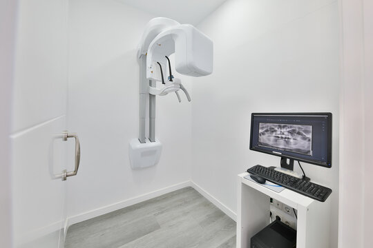 Modern dental x-ray room with panoramic scanner and monitor