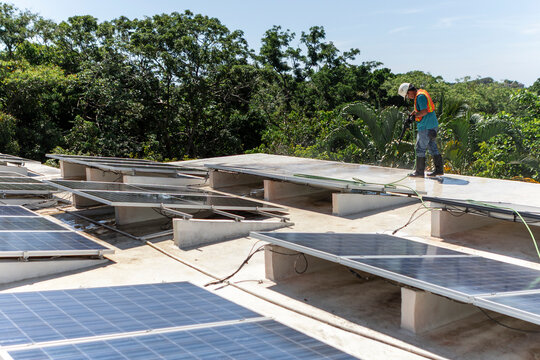 Worker maintaining solar panels on a rooftop