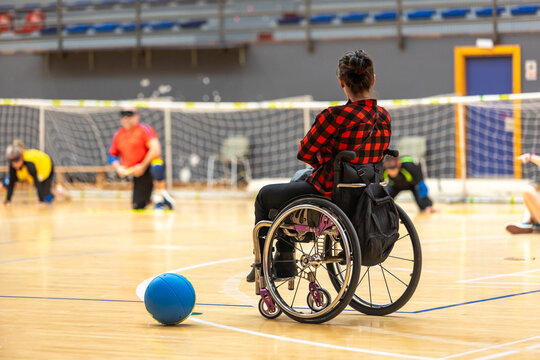 Wheelchair user observing goalball game in a gym