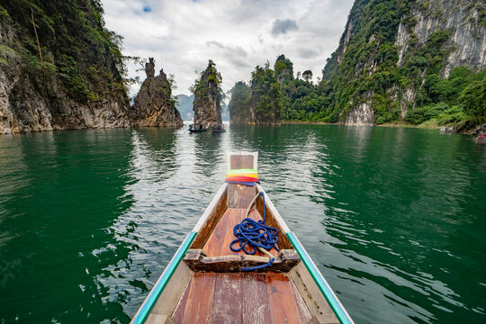 Longtail boat on Koh Tao lagoon with limestone cliffs