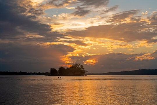 Lake Peten Itza at sunset with people silhouette on canoe, Flores Island, Guatemala.