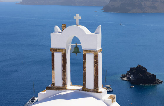 White church bell tower above the Aegean sea in Greece