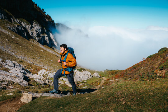 Hiker on mountain trail above cloud inversion in Pyrenees