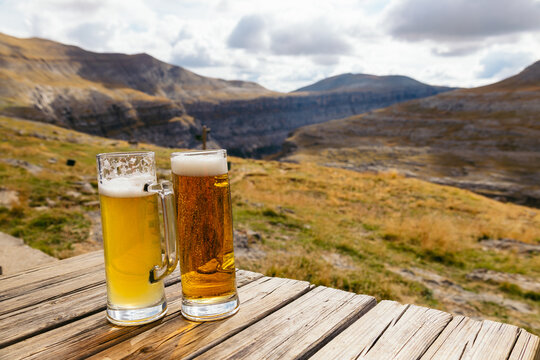 Beer mugs on rustic table with mountain view in Ordesa