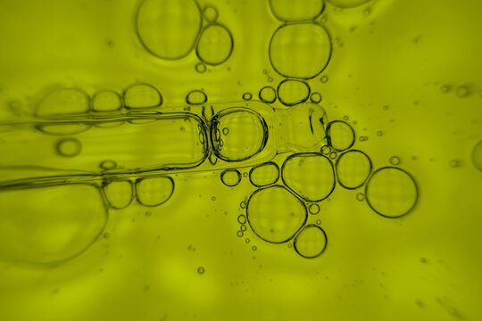 Abstract macro of oil bubbles in yellow liquid background