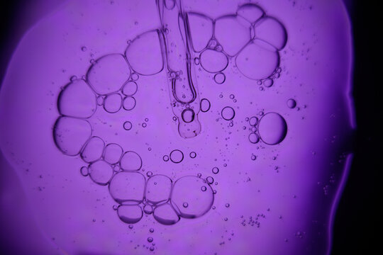 Abstract purple liquid with floating bubbles, macro view