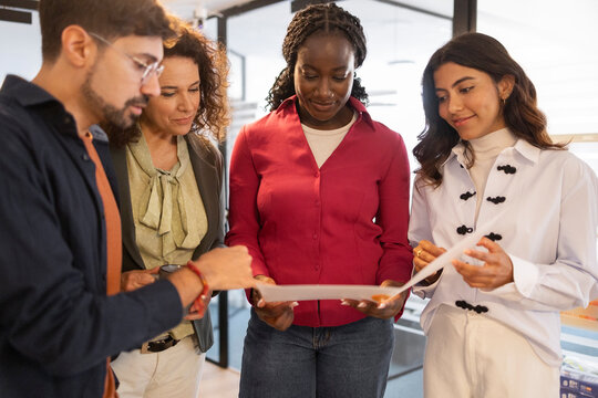 Diverse team reviewing documents in modern coworking office