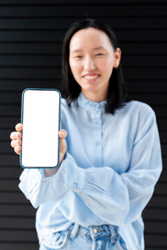 Gen Z Asian woman showing blank smartphone screen mockup