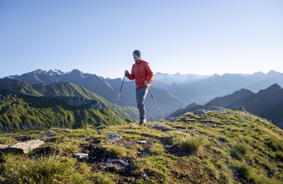 Hiker enjoying the mountain panorama in the morning, Venediger group, behind Dreiherrenkopf, Simonysitze and Gro&szlig;er Geiger, Hohen Tauern, Austria