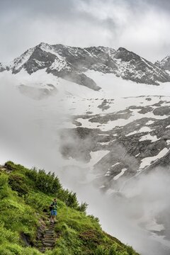 Mountaineers on a hiking trail, in the background glaciated peak Dosso Largo and glacier Schlegeiskees, cloudy atmospheric mountain landscape, ascent to Furtschaglhaus, Berliner H&ouml;henweg, Zillertal, Tyrol, Austria