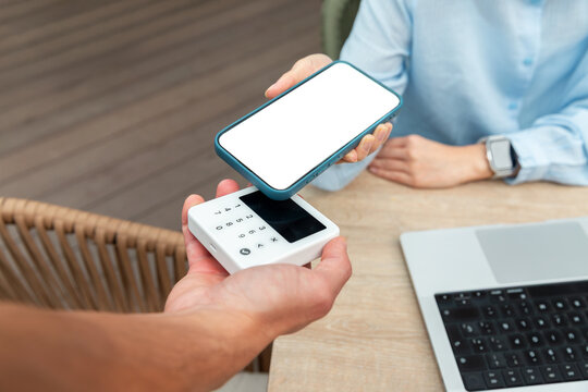 Mobile payment with smartphone and card reader at cafe table