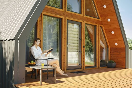 Woman enjoys bestseller book away from the bustle of the city in cozy country house