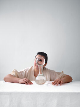 Woman gazing through crystal ball on minimalist table