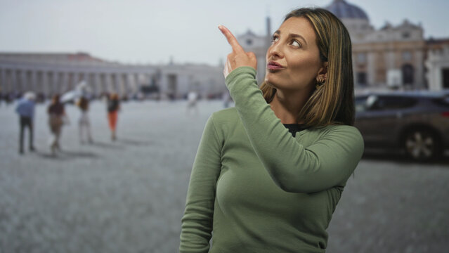 Woman points finger at the st peter's building in vatican square, smiling and gesturing toward the dome; playful travel.