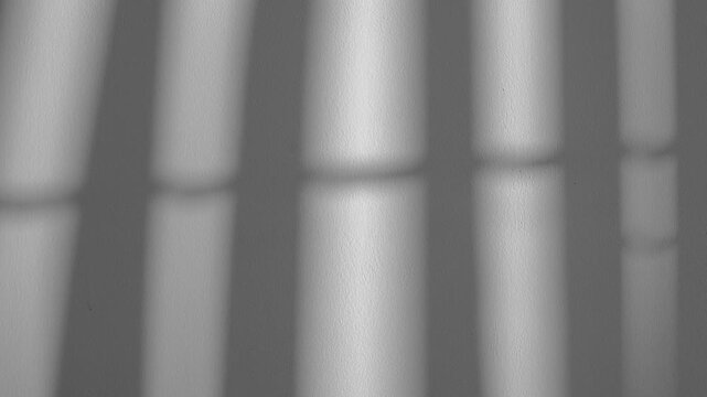 Shadow moving on gray concrete wall with soft natural sunlight. Minimal  Abstract window blind, light and shade pattern on grey  background with subtle motion and modern interior texture