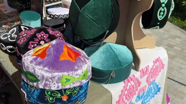 Traditional velvet skullcaps with embroidery and decorations at the fair