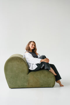 Woman Sitting Sideways Green Velvet Sofa Studio