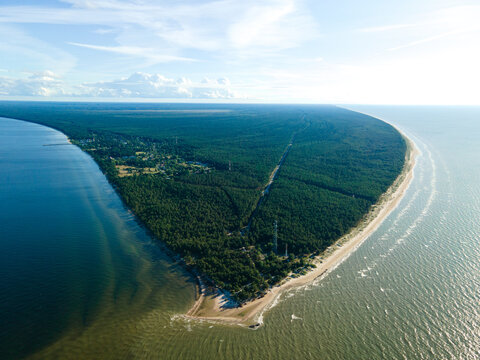 Aerial view of Cape Kolka where the Baltic Sea meets the Gulf of Riga, featuring dense pine forests and sandy coastlines in Kolka, Talsi Municipality, Latvia.