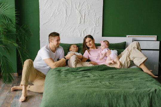 Happy Family With Children Relaxing On Bed