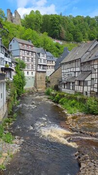 Beautiful town of Monschau in the Eifel region of western Germany. Half timbered houses, castle ruins and flowing river. Vertical video.
