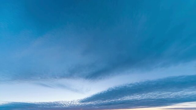 A vast expanse of blue sky dominates this image, featuring a color gradient that shifts from bright blue at the top to a richer, deeper blue in the center.