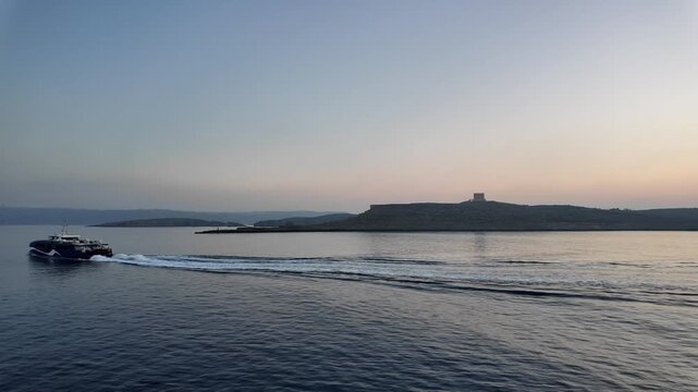 Comino, Malta 01.07.2026 - Comino during sunrise with a boat sailing around. Trip to Gozo, from Malta. High quality 4k footage