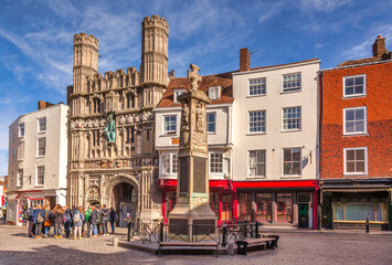 Fototapeta premium Canterbury Cathedral, the Buttermarket Entrance, with a Crowd of Young Tourists Outside. Beautiful Spring Morning. Also the War Memorial, on the Site of the Old Market Cross.