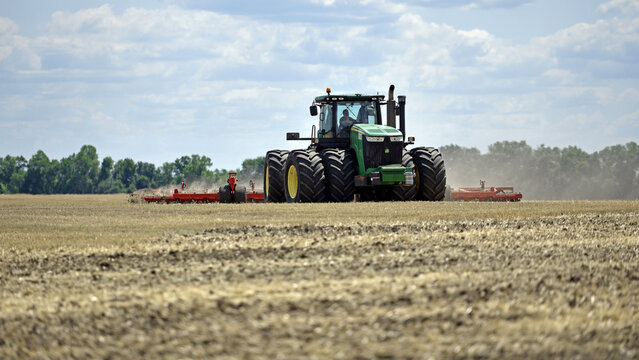 Kyiv, Ukraine, 19.07.2023. tractor in a field, tractor with a plow on an agricultural field. big green tractor working in the field, soil preparation, harvesting, business, agriculture. Editorial