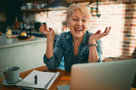 Smiling senior woman on video call at home kitchen